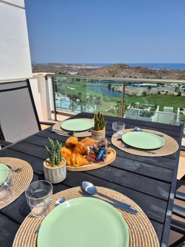 stół z talerzami jedzenia na balkonie w obiekcie Soleil-Sérénité Golf Aguilón w mieście Pilar de Jaravía