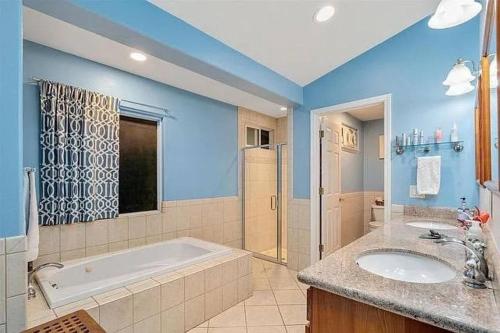 a large bathroom with a tub and a sink at Peaceful Olinda Getaway in Makawao