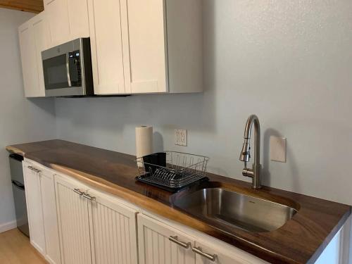 a kitchen with a sink and a microwave at Peaceful Olinda Getaway in Makawao