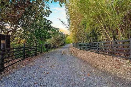 a dirt road with a fence on the side at Peaceful Olinda Getaway in Makawao