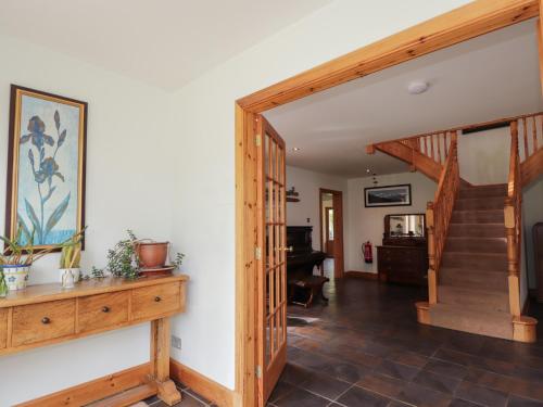 a living room with a wooden door and stairs at An Torr in Newtonmore