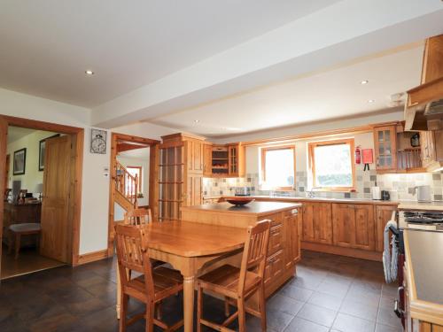 a kitchen with wooden cabinets and a wooden table at An Torr in Newtonmore