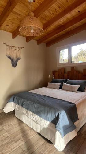 a bedroom with a large bed in a room with wooden ceilings at La casita in San Carlos de Bariloche