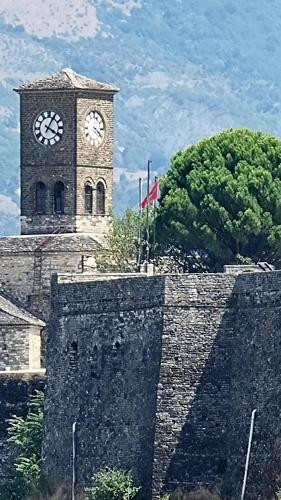 a clock tower on top of a stone wall at Çelo's house Gjirokaster in Gjirokastër