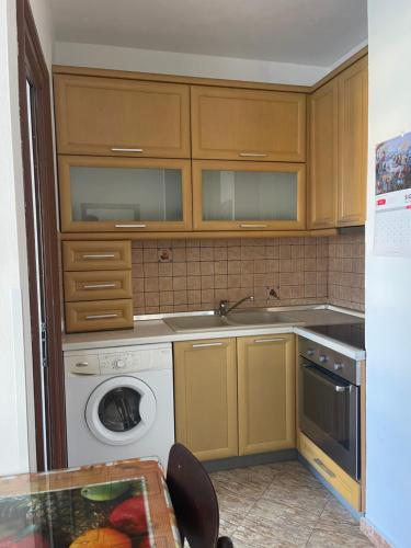 a kitchen with a sink and a washing machine at Sol Zoja Fusha e Aviacionit in Tirane