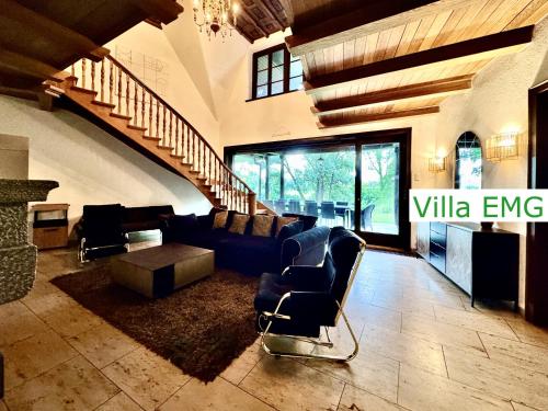 a large living room with couches and a staircase at Luxury Holidays Villa EMG Munich with Forest and Lake - Moosburg an der Isar in Moosburg