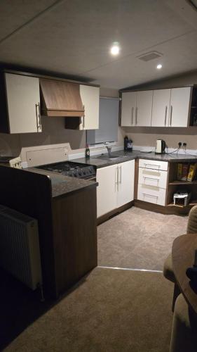a kitchen with white cabinets and a counter top at California Breeze in Scratby