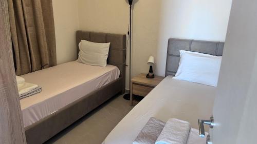 a bedroom with two beds and a lamp on a table at Pelagos studio in Áyios Pávlos