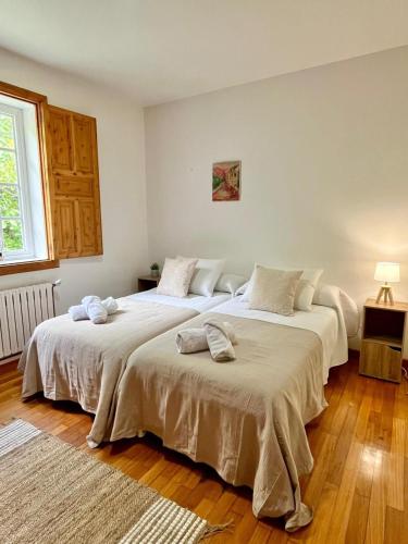 two large beds in a room with wooden floors at Airtegal Casa do Pepe Cedeira in Cedeira