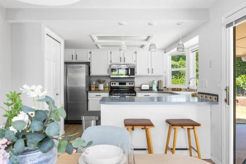 a kitchen with white cabinets and stainless steel appliances at Stylish Renovation, Perfect for Families & Pets, Garage Parking, Sleeps 10 in Boise