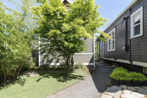 a black house with a tree in the yard at Blue Door Micro-Loft in Portland