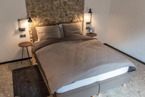 a bedroom with a large bed with two tables at Villa Libuse B&B in Pontebba