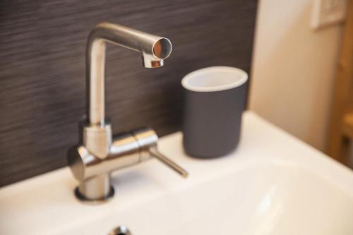 a sink with a faucet and a cup on it at Blue Door Micro-Loft in Portland