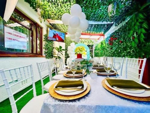 a table with white chairs and a table with plates and glasses at Executive Accommodation Bellville 1 in Bellville
