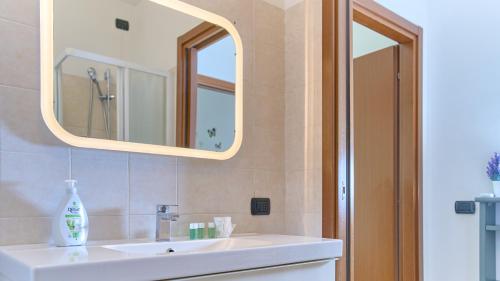 a bathroom with a white sink and a mirror at App 8 Accogliente Bilocale con Giardino in Monza
