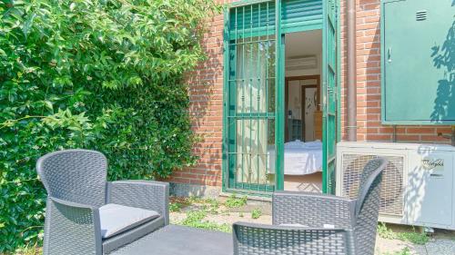 two chairs and a mirror in front of a building at App 8 Accogliente Bilocale con Giardino in Monza