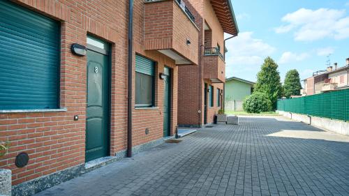 a brick building with a green door on a street at App 8 Accogliente Bilocale con Giardino in Monza