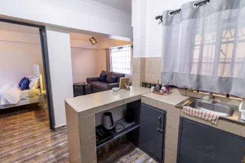 a kitchen with a sink and a couch in a room at Taraji's Nest Homestays in Nanyuki