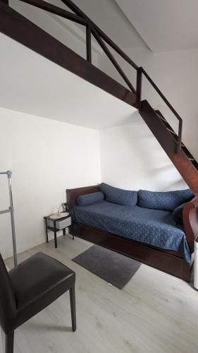 a living room with a blue couch and a chair at Casa do Páteo in Alcabideche