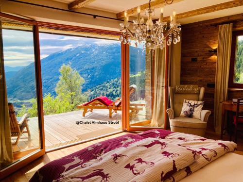 a bedroom with a bed and a large window at Chalet Almhaus Strobl in Radenthein