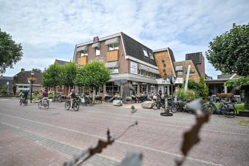 a group of people riding bikes down a street at De Stobbe hotel & suites in Ruinen