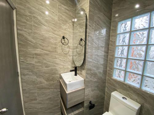 a bathroom with a sink and a toilet and a window at Maidy Luxury Hotel in Medellín