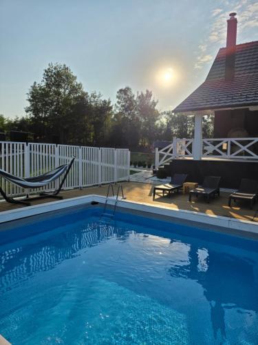 a swimming pool in front of a white fence at Moje srećno mesto in Arandjelovac