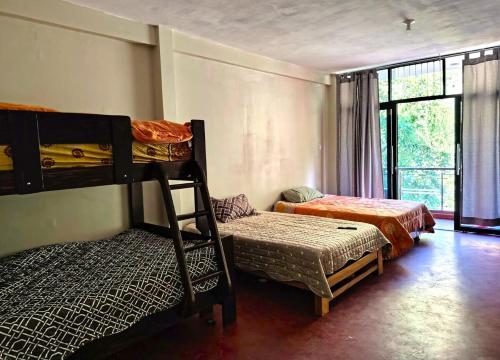 a bedroom with two bunk beds and a window at Casa familiar con parrilla, piscina, WiFi y cesped 