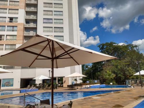 a large white umbrella next to a swimming pool at Park Veredas Flat Service Rio Quente - GO Apto 416 in Rio Quente