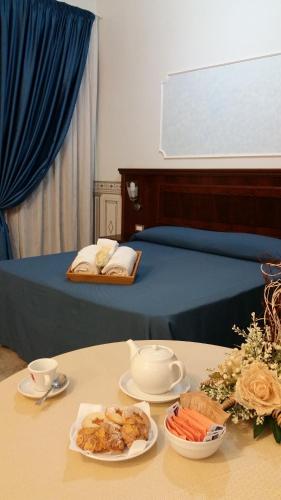 a bed with a table with plates of food on it at Grand Hotel Stella Maris Italia in Palmi
