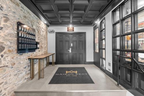 a hallway with a black door and a stone wall at La Maison Kent - Par Aneyro in Quebec City