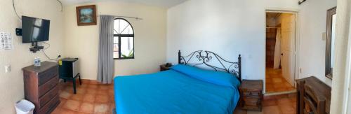 a bedroom with a bed with a blue blanket at Microhotel Ciudad del Carmen in Ciudad del Carmen