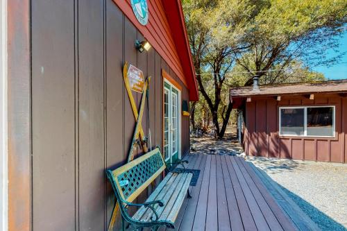 a green bench sitting on a deck next to a building at Hawkins Bar River Home in Hawkins Bar