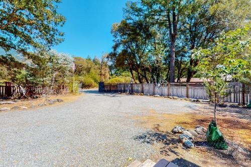 a tree in the middle of a road with a fence at Hawkins Bar River Home in Hawkins Bar