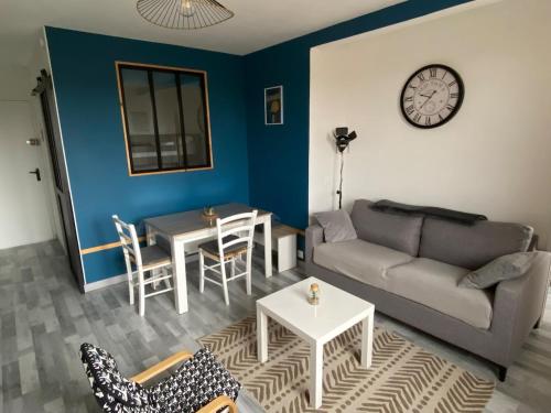 a living room with a couch and a table at Havre de paix en bord de mer in Houlgate