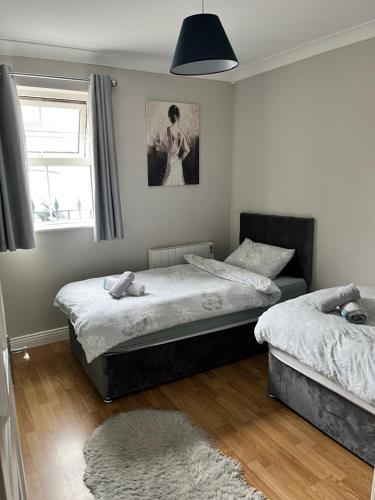 a bedroom with two twin beds and a window at Lahinch Central 3-Bed Retreat in Lahinch