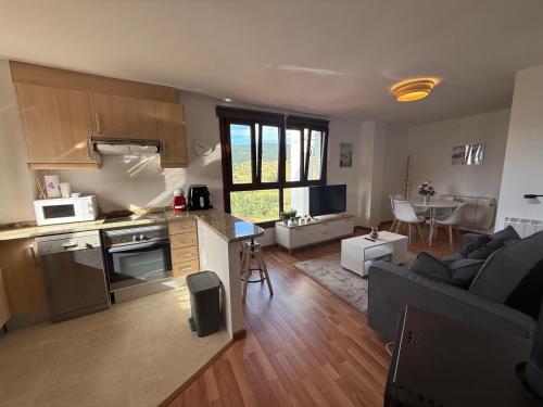 a kitchen and living room with a couch and a table at el mirador de ona in Valdelinares