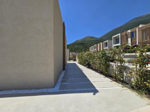 a walkway between two buildings with mountains in the background at Modern Luxury Villa in Green Coast with Sea View & Private Garden in Llogara