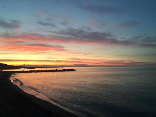 a sunset over the ocean with a beach at Al Giglio - Affittacamere in Cariati
