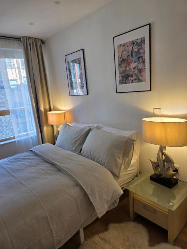 a bedroom with a bed and two lamps and a window at Hacienda in Manchester
