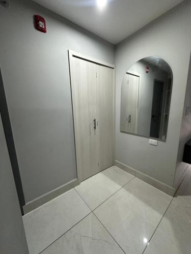 a bathroom with white walls and a mirror at Lujoso Apartamento en Eco Distrito in Tegucigalpa