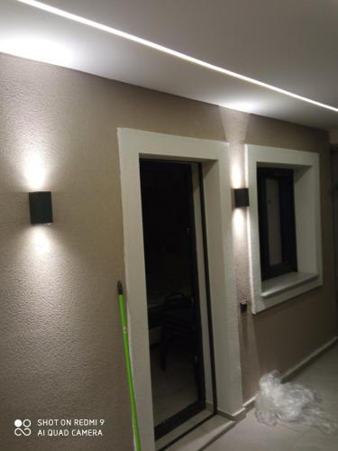 a room with a mirror and lights on the wall at Rosso Verde Apartments in Kókkinon Nerón