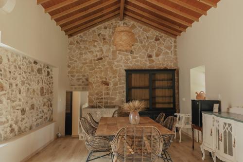 a dining room with a table and a stone wall at Quinta do Pinheiro Hotel E Eventos by Grupo Quinta dos Lagos in Valado dos Frades