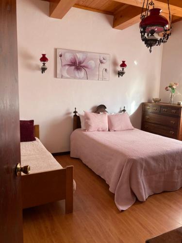 a bedroom with two beds with pink pillows and a dresser at Casa Vista Mar in Porto Martins
