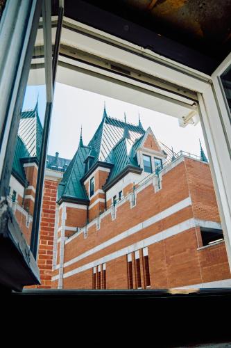 a view of a brick building through a window at La Maison Kent - Par Aneyro in Quebec City