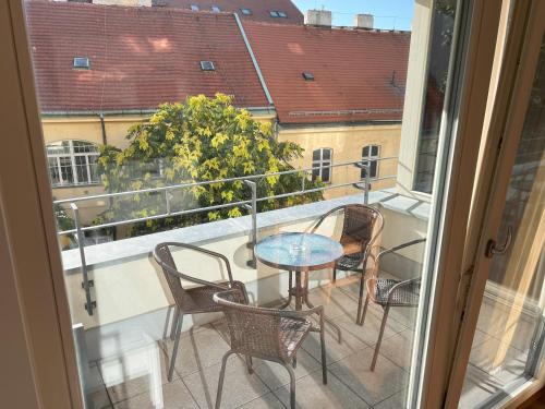 a balcony with a table and chairs and a window at Quiet Stay and Parking in Prague