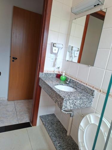 ein Badezimmer mit Waschbecken, Spiegel und Toilette in der Unterkunft Apartamento com piscina, 300m da praia in Ubatuba
