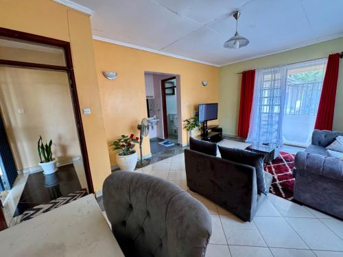 a living room with a couch and a tv at Yonga Apartment in Kisumu