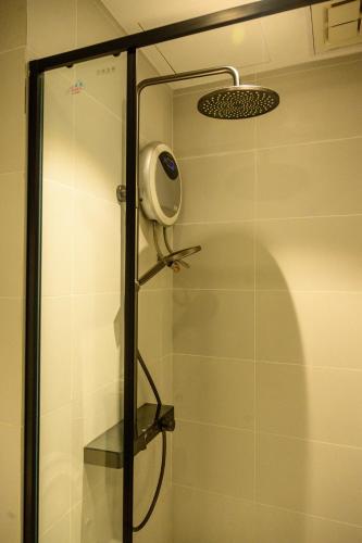 a shower with a glass door in a bathroom at Central Phnom Penh Sky Suite in Phnom Penh