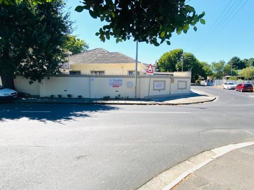 an empty street with a white fence and a building at Executive Accommodation Bellville 1 in Bellville